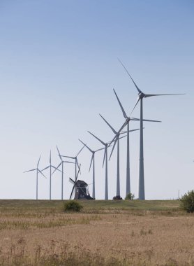 mavi gökyüzüne karşı eski Hollanda yel değirmeni ve modern rüzgar türbinleri 