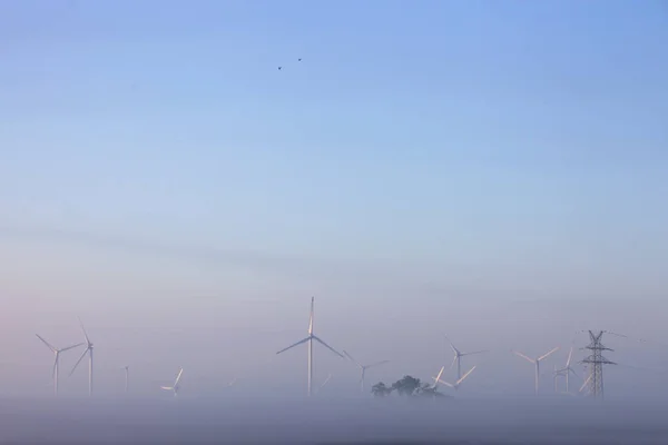 Turbine eoliche nella nebbia mattutina sulla campagna di ostfriesla — Foto Stock