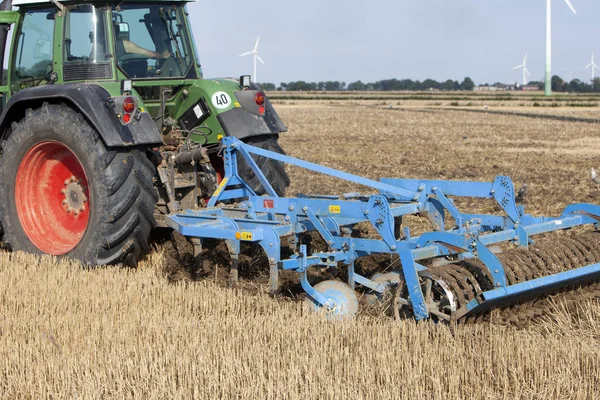 Agricoltore con trattore aratri campo a fine estate sulla campagna di — Foto Stock