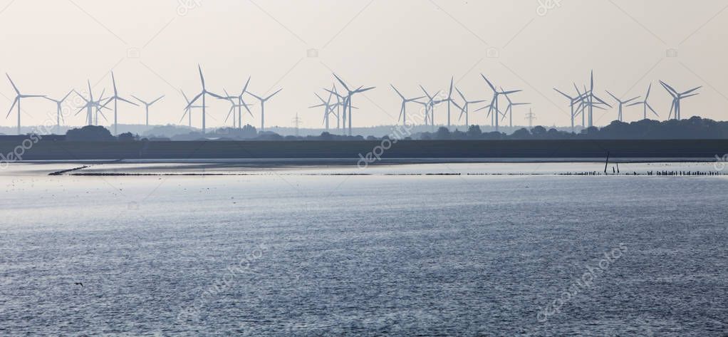 silhouette of wind turbine park on shore of north sea in german 