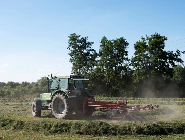 木のあるフランスの風景の中に草のターナーを持つトラクター — ストック写真