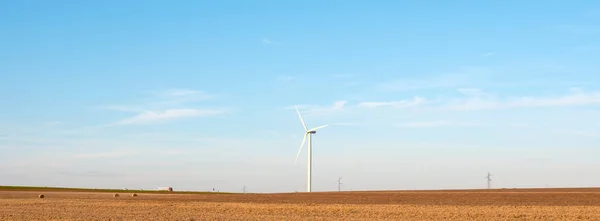 Fransa 'nın kuzeyinde hasat sonrası tarlalarda arka planda rüzgar türbinleri var. — Stok fotoğraf