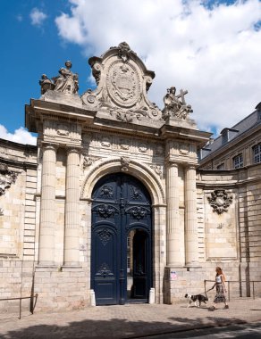 Kadın ve köpek güneşli bir günde müzenin verandasından geçiyorlar.