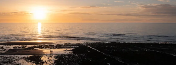 Silhuetas de pessoas na praia em Ault em normandy francês durante o pôr do sol — Fotografia de Stock