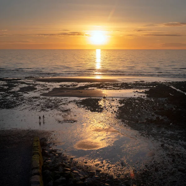 Siluetas de personas en la playa en Ault en normandía francesa durante la puesta del sol — Foto de Stock