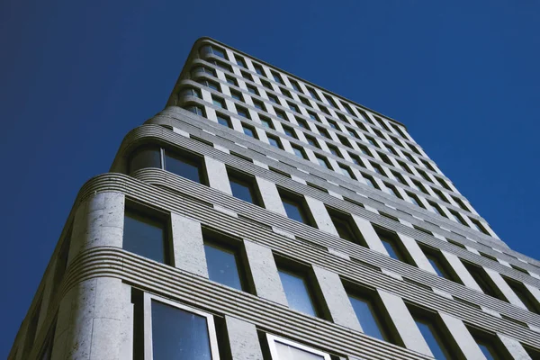 Silver modern office sky-scraper building in front of blue sky