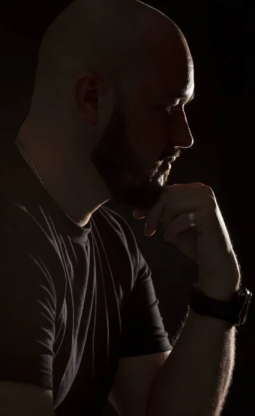 Silhouette of a bald man on a black background