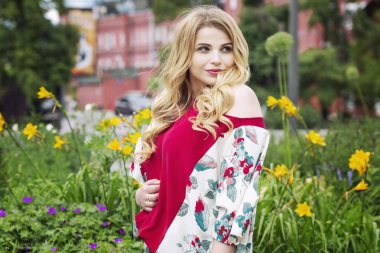 Güzel ve genç birbayan çiçeklerle bir parkta yakın çekim