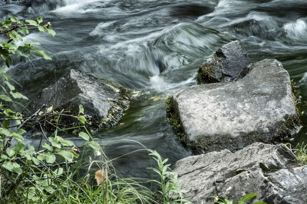 Powerful flow of water over the stones, close-up