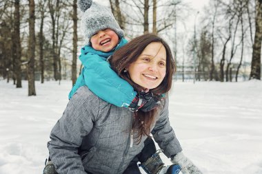 Anne ve küçük oğlu kış manzara karda oynayan