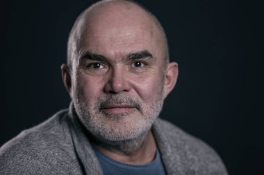 Yaşlı kel gri saçlı adam, yakın çekim, siyah arka plan