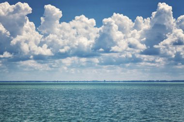 Turkuaz deniz ve çıplak gökyüzünde parlak kümülüs bulutlar güzel manzara