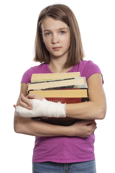 Tiener meisje met zere hand en boeken — Stockfoto