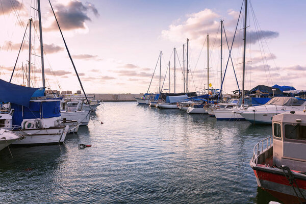 Яхты причаливают в гавани, красивый розовый закат

