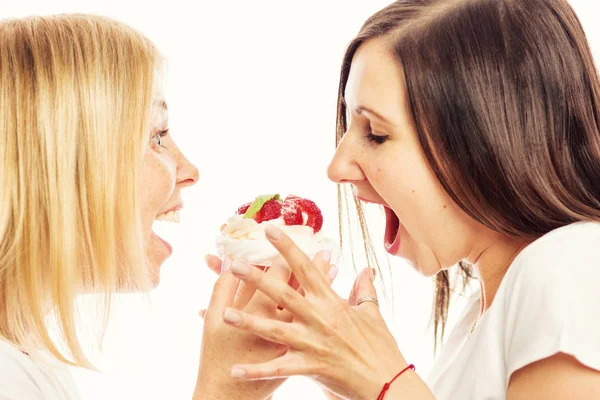 Jonge vrouwen eten taart, witte achtergrond — Stockfoto