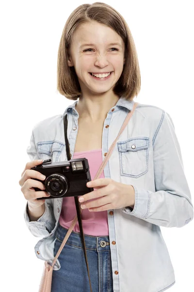 Laughting cute teen girl with a camera, close-up, isolated on white background — Stock Photo, Image