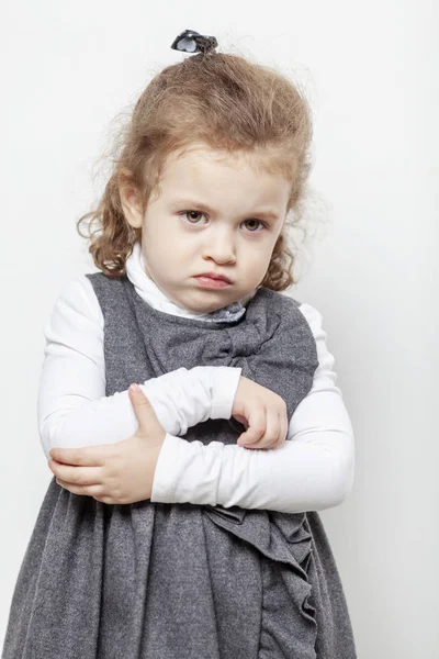 Cute little girl, evil emotion, close-up, light background — Stock Photo, Image