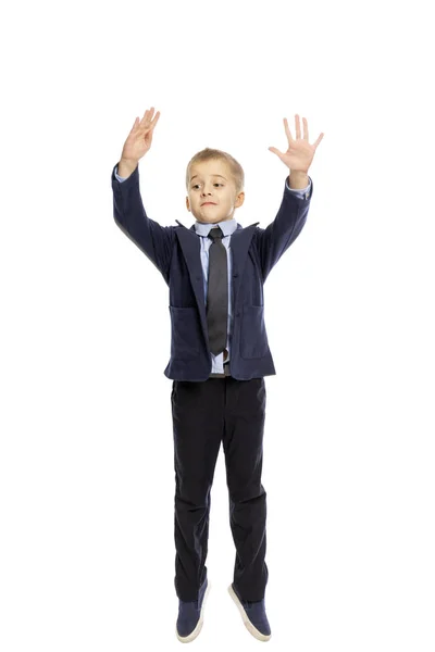 Junge in Schuluniform springt, isoliert auf weißem Hintergrund — Stockfoto