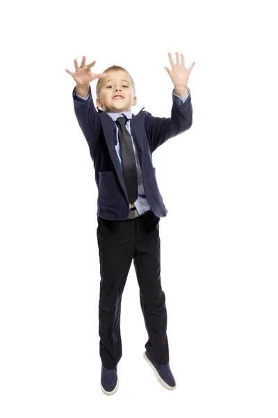 Junge in Schuluniform springt, isoliert auf weißem Hintergrund, — Stockfoto