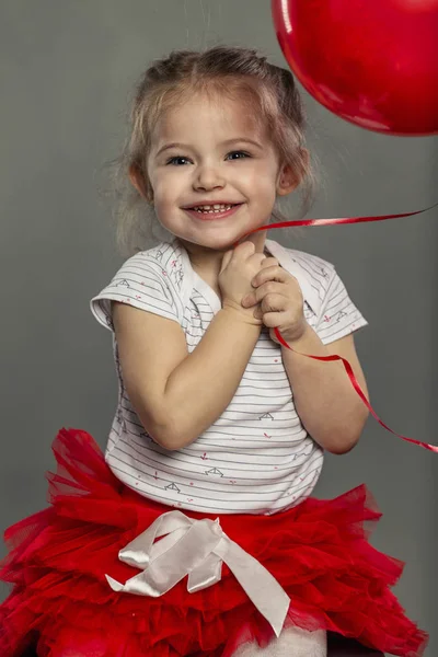 Aranyos kislány, a kezében egy léggömb nevet. közeli kép: — Stock Fotó