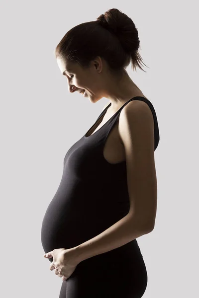 Happy pregnant woman waiting. Isolated on light gray background. — Stock Photo, Image