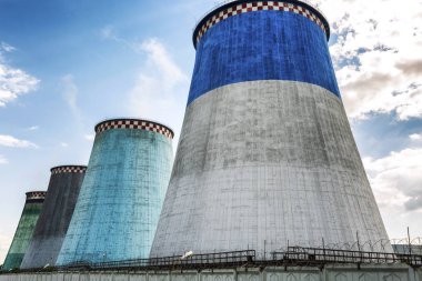 Parlak mavi gökyüzü arka plan üzerinde çok renkli soğutma kuleleri.