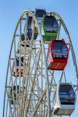 Güneşli bir günde parlak mavi gökyüzü bir arka plan üzerinde çok renkli kabin ile dönme dolap. Close.
