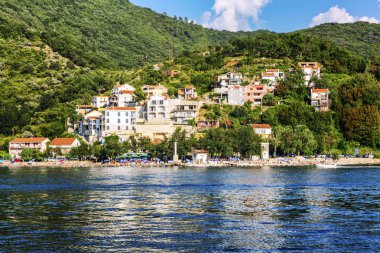Kotor, Karadağ, 07.27.2016. Adriyatik kıyısındaki dağlarda küçük eski bir kasaba. Dağlarda yemyeşil bitki örtüsü ortasında turuncu çatılı güzel taş evler.
