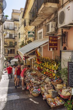 Taormina, İtalya, 08/30/2016: Eski kentte dar bir sokak. İnsanlar meyve ve hediyelik eşya satın alıyor..