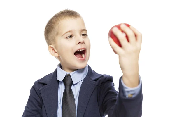 Un écolier affamé en costume mange une pomme rouge. Gros plan. Isolé sur fond blanc . — Photo