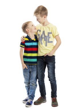 İki kardeş birbirlerine bakarak kucaklaşır ve gülümserler. Dostluk ve sevgi. Beyaz arka planda yalıtılmış.