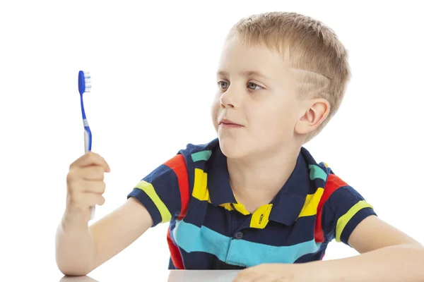 Lachende jongen met een tandenborstel in zijn hand. Close-up. Geïsoleerd op een witte achtergrond. — Stockfoto