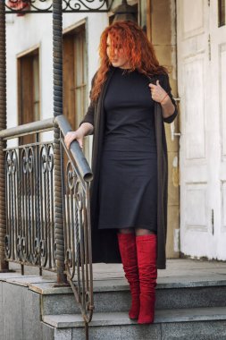 Şehir caddesinde parlak kızıl saçlı genç bir kadın.. 
