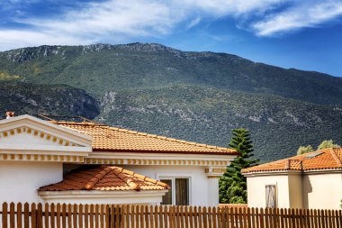 Dağların ve parlak mavi gökyüzünün arka planında güzel evler.