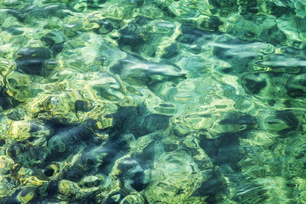 Transparente superfície do mar azul-turquesa com brilho solar, fundo. Close-up. Espaço para texto . — Fotografia de Stock