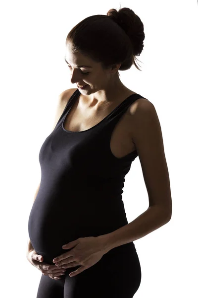 Silhouette of a smiling pregnant woman. Backlight. Isolated on a white background. — Stock Photo, Image