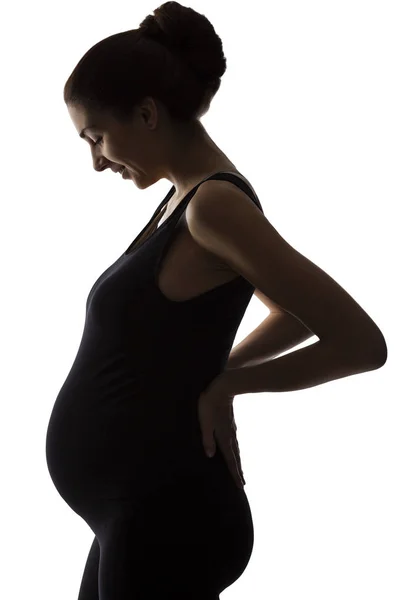 Silhouette of a smiling pregnant woman. Backlight. Isolated on a white background. — Stock Photo, Image