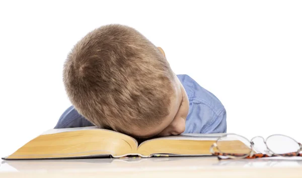 Een jongen van school leeftijd slaapt op de boeken. Geïsoleerd op een witte achtergrond. — Stockfoto