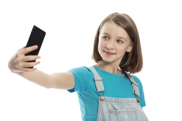 Lächelndes Teenie-Mädchen wird am Telefon fotografiert. Nahaufnahme. isoliert auf weißem Hintergrund. — Stockfoto