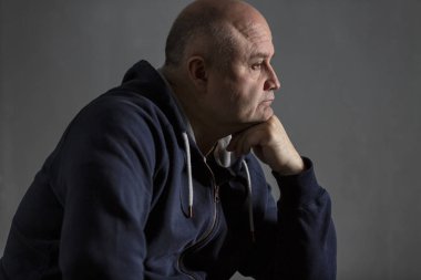 Üzgün orta yaşlı kel adam. Düşük anahtar. 