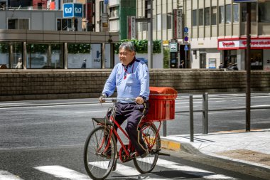 Tokyo, Japonya, 04/12/2019: Bir şehir caddesinde bisikletli bir adam.