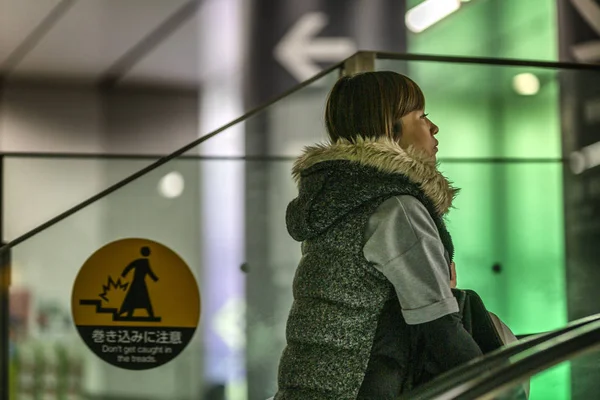 日本东京，2019年4月12日：地铁自动扶梯上的亚洲女孩。特写. — 图库照片