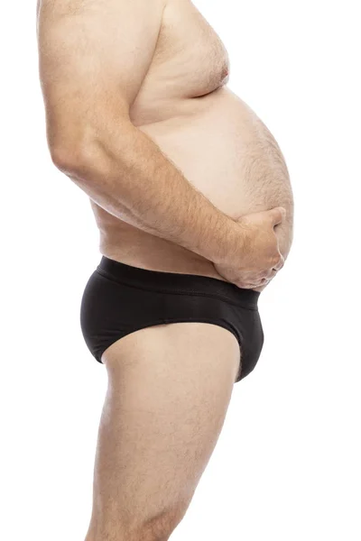 Adult man with a big hairy belly, side view. Close-up. Isolated on a white background. Stock Picture