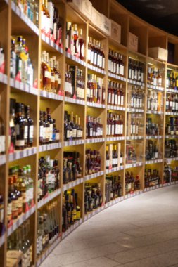 Büyük şarap rafları. Birçok farklı alkollü içecek. Lüks enoteca. Fotoğraf bulanık..