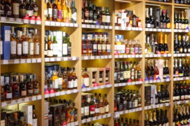 Büyük şarap rafları. Birçok farklı alkollü içecek. Lüks enoteca. Fotoğraf bulanık..