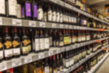Süpermarket raflarında şarap çeşitleri. Fotoğraf bulanık..