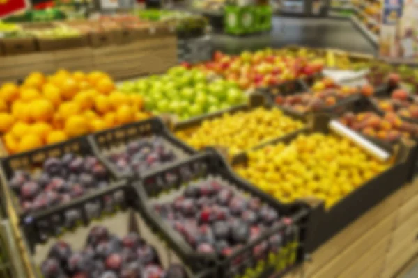 Frutas diferentes no balcão no supermercado. A foto está desfocada . — Fotografia de Stock