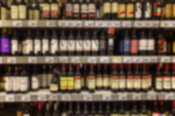 Assortiment wijnen op de planken van de supermarkt. De foto is wazig. — Stockfoto