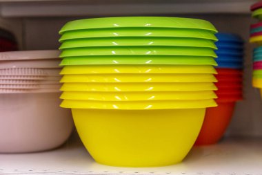 Mağazada rafta çok renkli plastik kase. Close.