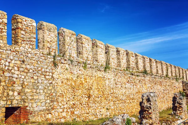 Old fortress wall on the background of bright blue sky. Space for text.